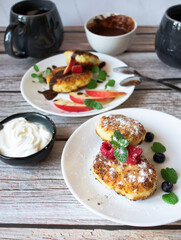 Delicious cheesecakes with berries and sour cream. Delicious breakfast. Morning