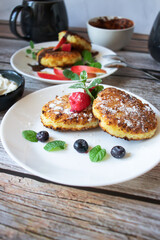 Delicious cheesecakes with berries and sour cream. Delicious breakfast. Morning