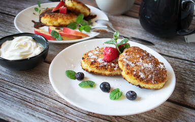 Delicious cheesecakes with berries and sour cream. Delicious breakfast. Morning