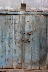 Blue door with locks, chains & a swastika about