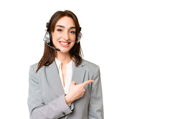 Telemarketer caucasian woman working with a headset over isolated chroma key background pointing to...
