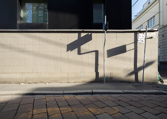 Detail of a wall in the city of Milan, with signposts forming dry shadows etched on the wall.