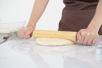 simple home cooking. Close up of asian woman baking homemade pastry and rolling dough on white...