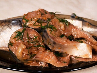 Marinated mackerel on a black fish plate. Close-up, selective focus.