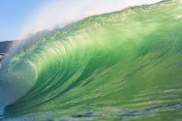 perfect green wave breaking on the beach