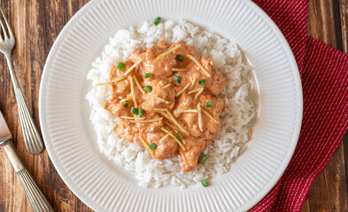 Brazilian style Chicken strogonoff with rice and potato straw on wooden table. Flat lay