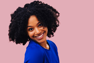 Close up studio shot of an African American woman with afro hair smiling