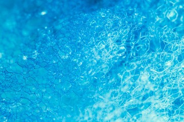 Closeup of blue translucent soap bubbles floating on the water surface, perfect for backgrounds