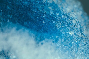 Fototapeta premium Closeup of blue translucent soap bubbles floating on the water surface, perfect for backgrounds