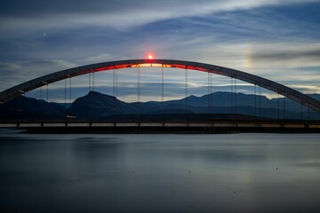 Fototapeta premium Beautiful nighttime scene of the Theodore Roosevelt Lake Bridge illuminated by a bright light