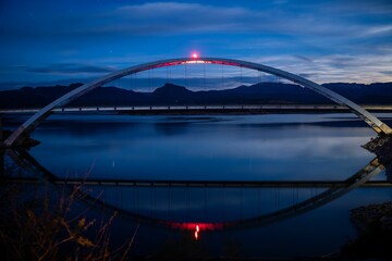 Beautiful nighttime scene of the Theodore Roosevelt Lake Bridge illuminated by a bright light