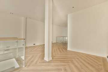 an empty room with white walls and wood flooring on the right, there is a mirror in the corner