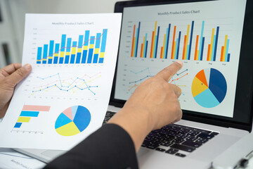 Asian accountant working and analyzing financial reports project accounting with chart graph in...
