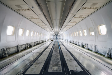 Commercial airplane under heavy maintenance. Inside of passenger cabit without seats and interior..
