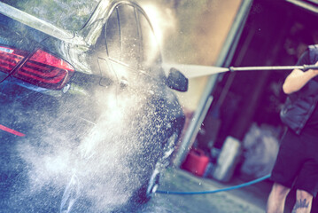 Summer car wash. Car cleaning with high pressure water.