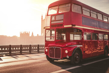 Classic English Red Bus on the Westminster Bridge and Big Ben Tower in the background.