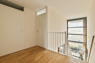 an empty room with wood flooring and sliding glass door leading out to the balcony area where there is no furniture