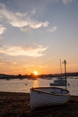 Vertical shot of a boat on a beach during the sunset in Teignmouth, England
