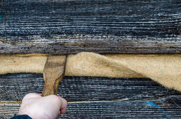 Male hands caulk log walls