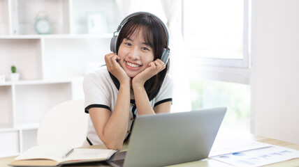 Young studying online uses his laptop in a live performance to communicate with his friends and teachers, Using laptops and data graphs in class, Online communication, Social distancing.