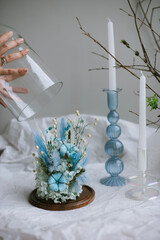 Beautiful glass cloche with dry blue flowers inside, vertical image 