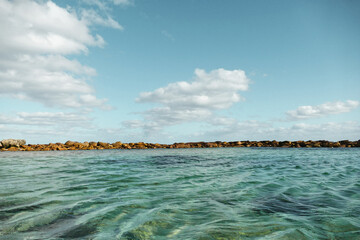Majestic Seascape: Coastline Rocks and Blue Water with Cloudy Sky