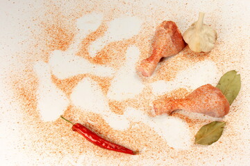 Raw chicken legs with spices and pepper  on a white background. Fresh chicken drumsticks background
