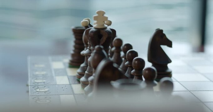 Man playing chess and doing a move with pieces - concept of strategy