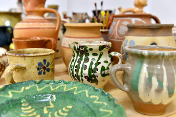 Old traditional colored romanian handmade pottery displayed on a table.