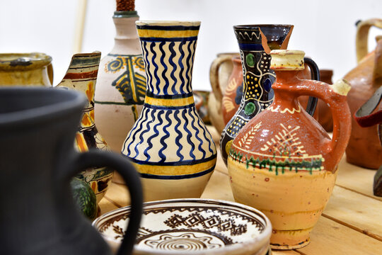 Old traditional colored romanian handmade pottery displayed on a table.
