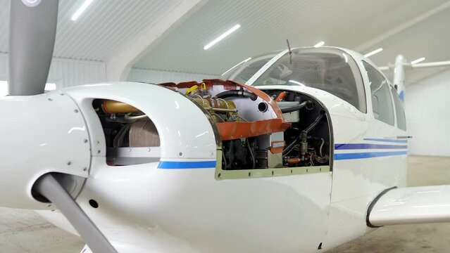 Single engine propeller airplanes parked in a closed aircraft hangar. Internal parts Of Aircraft Engine. Concept: Aircraft construction, aviation, airplane turbine, engine closeup.