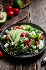 Salad with feta cheese, avocado and tomatoes in a bowl