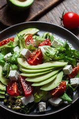 Salad with feta cheese, avocado and tomatoes in a bowl