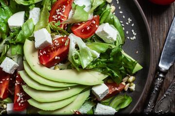 Salad with feta cheese, avocado and tomatoes in a bowl