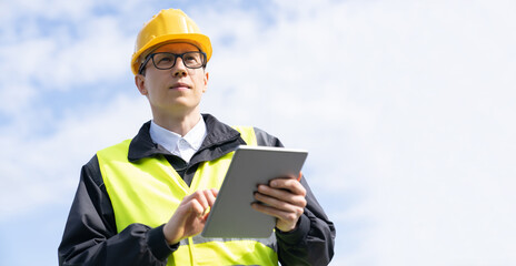 Engineer with digital tablet on a background of blue sky