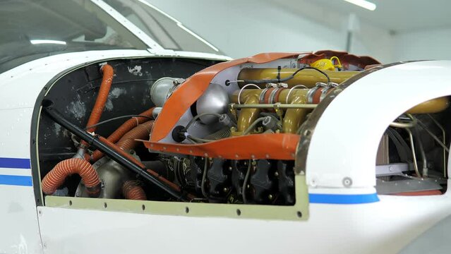 Single engine propeller airplanes parked in a closed aircraft hangar. Internal parts Of Aircraft Engine. Concept: Aircraft construction, aviation, airplane turbine, engine closeup.