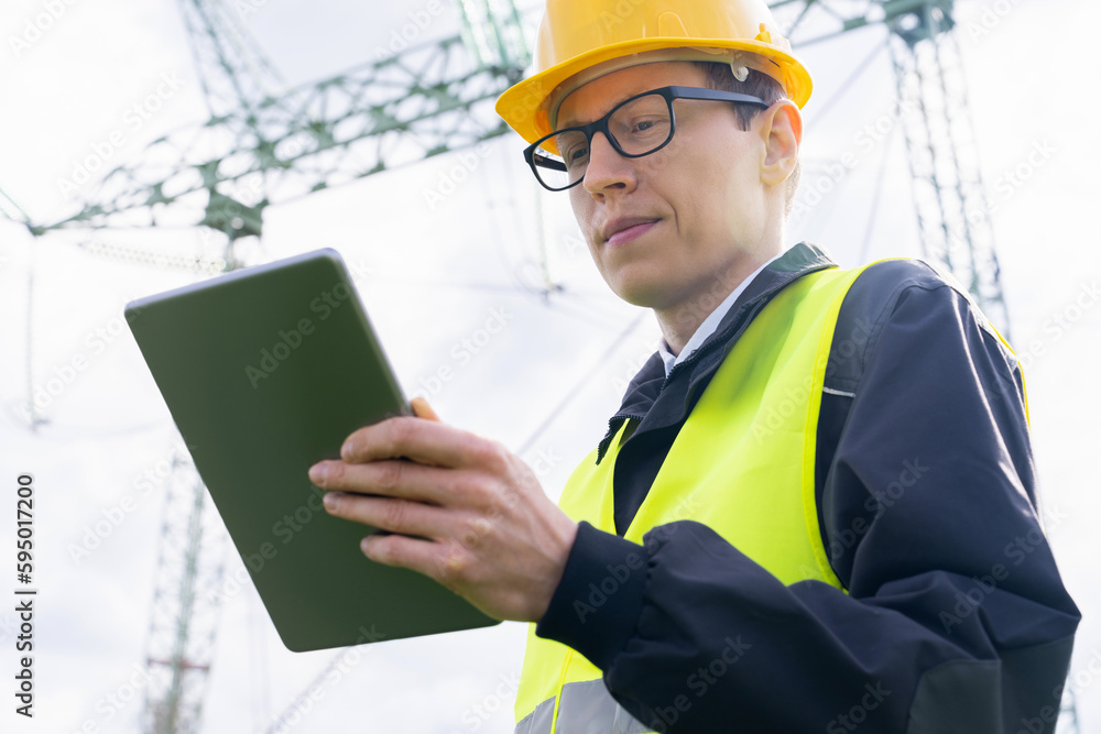 Poster engineer with digital tablet on a background of power line tower