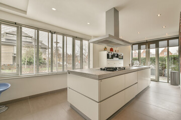 a modern kitchen with white cabinets and marble counter tops in front of the window looking out onto an outside patio