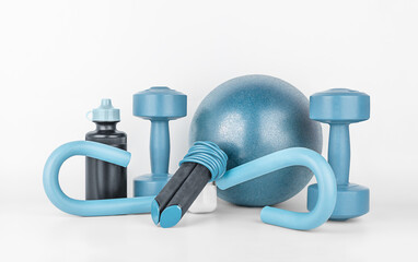 Obraz na płótnie Canvas Fitness equipment on a gray background, front view, close-up. Dumbbells, sports bottle of water, jump rope, s-shaped leg exercise machine, fitness ball. Home workout. Fitness and activity. 
