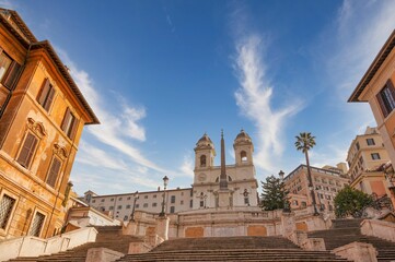 Spanish Steps monument under a blue sky with clouds in Rome, Italy.