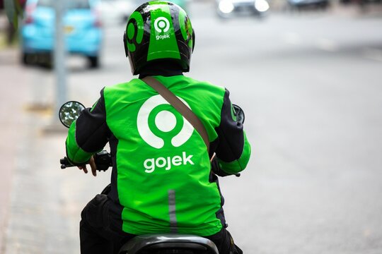 Rear view of a Gojek food delivery driver on the streets of Bali, Indonesia