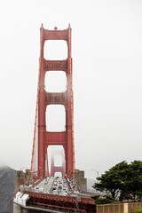 Iconic Golden Gate Bridge in San Francisco, California with cars driving along it covered by fog