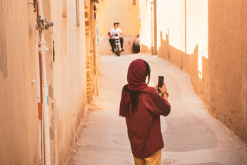Fototapeta na wymiar Caucasian woman tourist explore walk through arch corridor in Yazd old town area