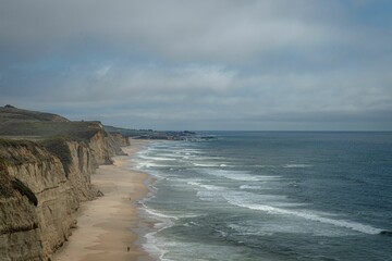 Coastal landscape featuring a Pescadero State Beach with white and foamy waves in California