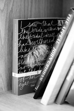 Grayscale shot of the book Great Expectations, Novel by Charles Dickens on a shelf
