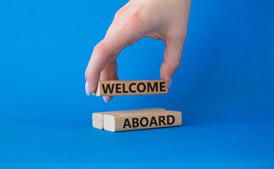 Welcome aboard symbol. Concept word Welcome aboard on wooden blocks. Beautiful blue background. Businessman hand. Business and Welcome aboard concept. Copy space