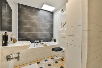 a bathroom with black and white tiles on the walls, tub, toilet, sink and shower stall in it's corner