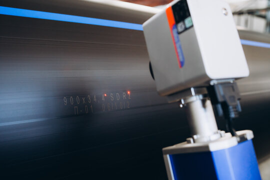 Laser Marking Machine Engraving. Manufacture of plastic water pipes of the factory.