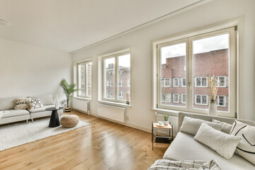 a living room with hardwood flooring and windows looking out onto the street in front of the apartment's buildings