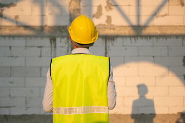 Back of Asian  Engineering man looking to construction analyzing about project plan